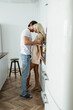 © LIGHTFIELD STUDIOS - happy man flirting with blonde woman in kitchen