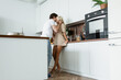 © LIGHTFIELD STUDIOS - man flirting with happy girlfriend in kitchen
