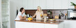 © LIGHTFIELD STUDIOS - happy man looking at cheerful girlfriend with glass of orange juice in kitchen, banner