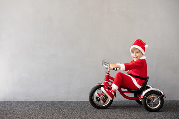 Canvas Print - Happy child riding bike. Christmas holiday concept