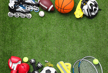 Different sport equipment on green grass, flat lay. Space for text