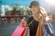 © maxbelchenko - Young Woman in shopping. Stylish  woman with shopping bags walking around the city after shopping. Black friday, sale, consumerist, lifestyle concept.