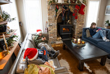 Brothers And Sister In Santa Hats Using Technology In Living Room