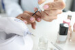 © megaflopp - Woman doing her own manicure with pink nail polish closeup