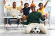 © Prostock-studio - Happy african american football fans watching match on TV