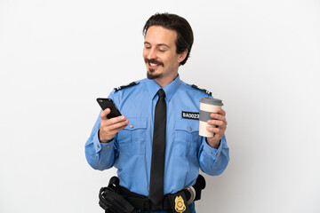 Wall Mural - Young police man over isolated background white holding coffee to take away and a mobile