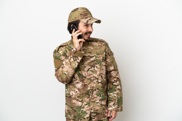 Canvas Print - Soldier man isolated on white background keeping a conversation with the mobile phone with someone