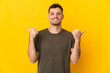 © luismolinero - Young caucasian handsome man isolated on yellow background with thumbs up gesture and smiling