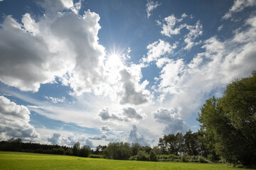 field and blue sky with crazy clouds