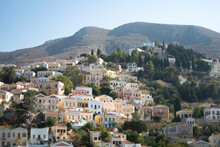 Beautiful Symi Island, Greece. View Of Neo Classical Houses On A Hillside.  Landscape View