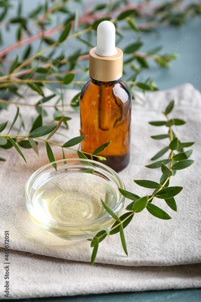 Bowl with eucalyptus oil and dropper bottle on table