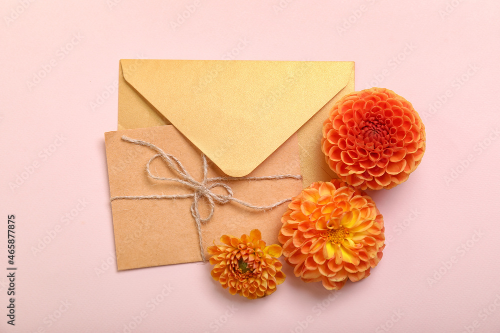 Envelopes and dahlia flowers on color background
