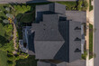 Aerial top down view of a complex hip and valley pitched roof  with three dormers on a new construction American luxury single family house real estate
