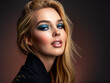 Portrait of sexy blonde woman with a beautiful face. Fashion model with long hair, studio shot.  Photo of young stylish  woman in black clothes with  blue make-up.