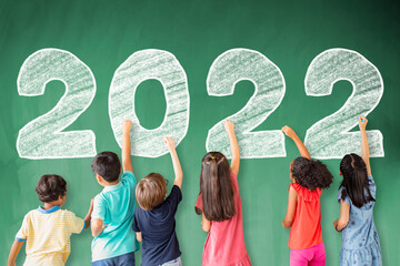 Wall Mural - School children drawing 2022 new year on the chalkboard.