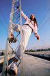 © chika_milan - Rebellious teenage girl climbing on the metal construction at the train station.