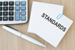 © Volha - note card with text STANDARDS on wooden table