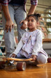© luckybusiness - A cute little girl sitting on the skateboard at home and playing with her father. Family, home, playtime
