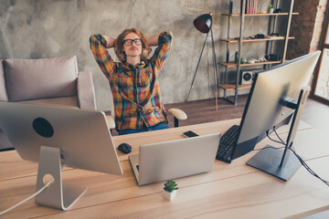 Photo of young man sit chair office hands behind head rest relax comfort dream sleep break programmer indoors