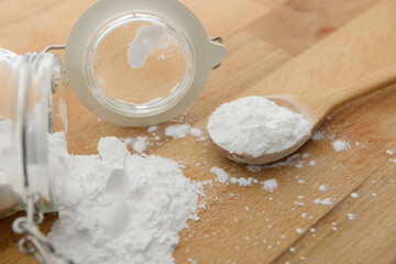 Wall Mural - Close-up of tapioca starch or flour powder in wooden spoon with wooden background