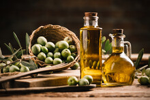 Olive Oil With Fresh Olives On Rustic Wood