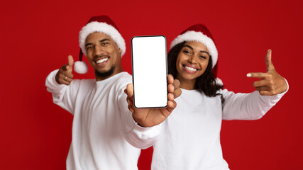 Positive african american lovers showing cellphone with empty display