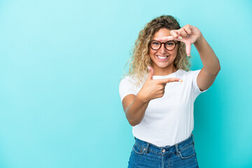 Wall Mural - Girl with curly hair isolated on blue background focusing face. Framing symbol