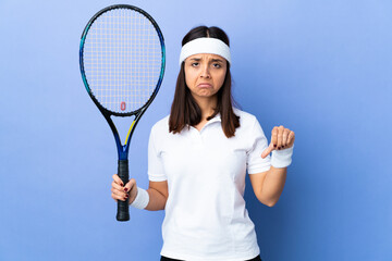 Young woman tennis player over isolated background showing thumb down with two hands