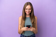 © luismolinero - Young Lithuanian woman isolated on purple background sending a message with the mobile