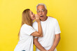 Middle age couple isolated on yellow background whispering something
