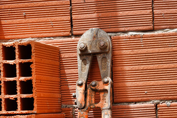 Wall Mural - Rusty bolt cutter on a brick wall background