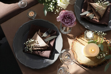 Festive table setting with beautiful tableware, candles and floral decor indoors, top view