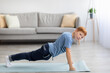 © Prostock-studio - Athletic boy planking on fitness mat at home