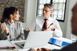 © Goran - Business people talking to each other while having a business meeting in the office