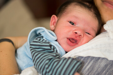 Canvas Print - Closeup of a cute baby boy resting on the shoulder of his mother