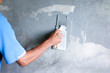 Painter painting wall with rectangular trowel.