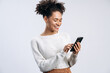 © speed300 - Portrait of cheerful multiracial curly woman holding smartphone at her hands and typing message in front of the camera. Technologies concept