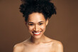 © speed300 - Portrait view of the multiracial woman smiling toothy and posing to the camera while standing in front of the brown wall. Stock photo
