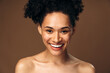 © speed300 - Laughing vivacious young multiracial woman with a beaming smile posing over brown background. Happy woman with naked shoulders laughing