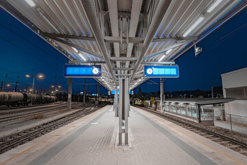 Wall Mural - Train platform at Schwechat train station in Austria at night. View of train platform in tracks and blue night sky.