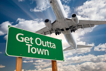 Wall Mural - Get Outta Town Green Road Sign Against Dramatic Clouds and Sky.