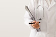 © zhane luk - close up of doctor standing with pen and medical records in hand on white background.