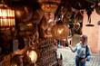 Travel and shopping. Young traveling woman with choose presents in copper souvenir handicraft shop in Morocco.