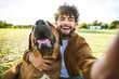 © Davide Angelini - Young happy man taking selfie with his dog in a park - Smiling guy and puppy having fun together outdoor - Friendship and love between humans and animals concept
