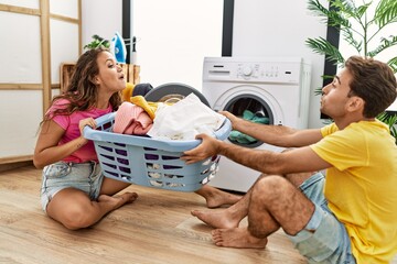 Canvas Print - Man and woman couple pulling laundry basket at laundry room