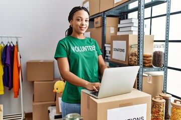 Canvas Print - Young african american woman wearing volunteer uniform working at charity center