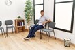 © Krakenimages.com - Young hispanic man smiling confident sitting on chair at waiting room