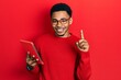 © Krakenimages.com - Young african american man using touchpad device surprised with an idea or question pointing finger with happy face, number one