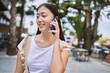 © Krakenimages.com - Young chinese girl smiling happy talking on the smartphone at the city.