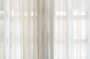 airy or thin and transparent white sheer curtain with texture for see through and soft light on window and close in room for home street or hotel interior decor to beige bright architecture background